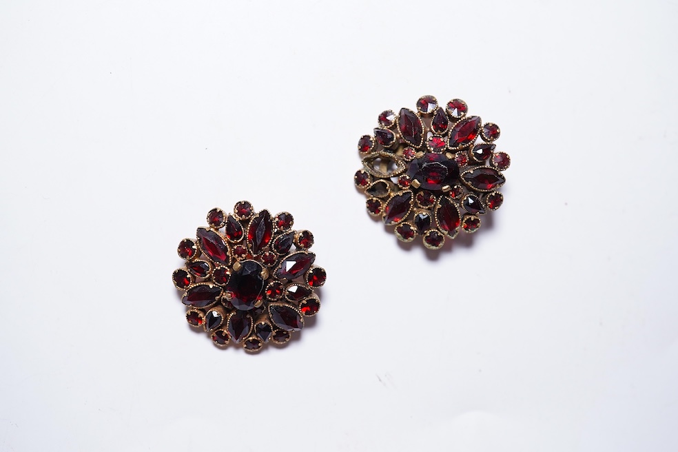 A suite of garnet and paste jewellery, comprising: a brooch, 5cm diameter; a bangle, inner circumference 16cm; two rings, sizes I and M; a pair of earrings, and a single earring, each set with rose-cut garnets; and a pai